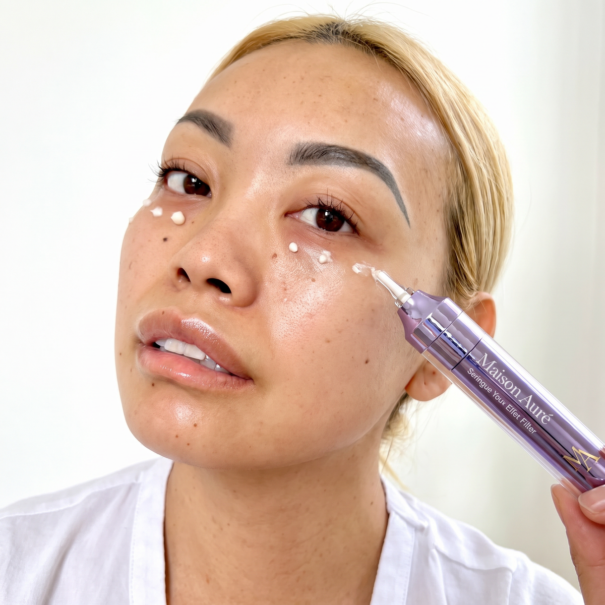 Gros plan : points de crème nacrée de la Seringue Yeux Effet Filler Maison Auré déposés sous l'œil